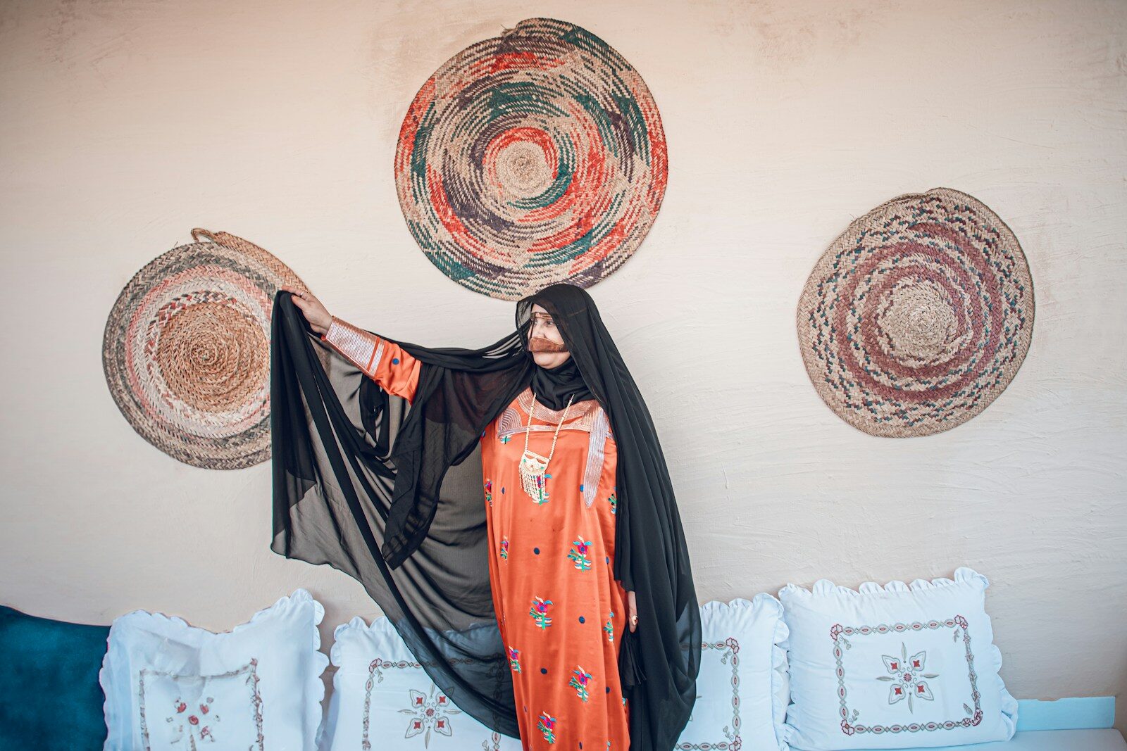مجموعات Woman in traditional attire poses elegantly.
