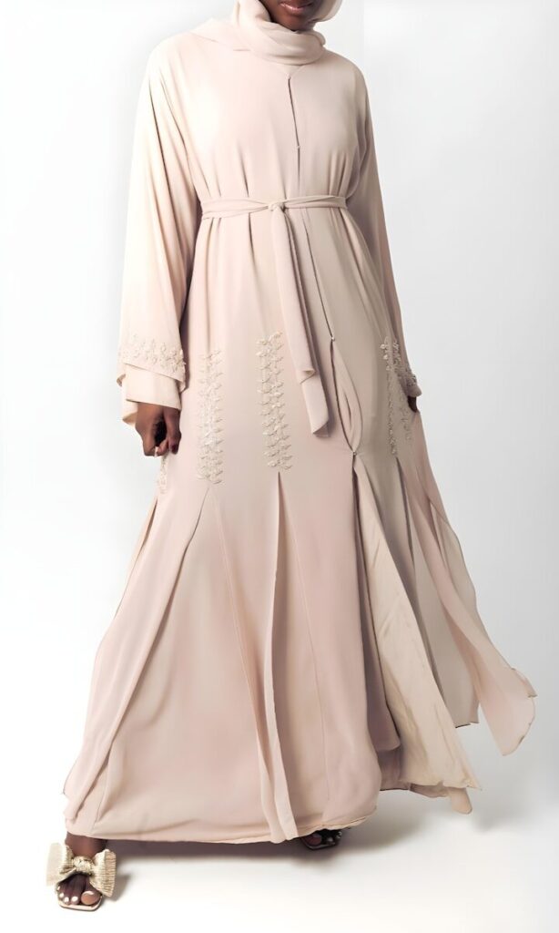 Why Korean Crepe Is the Perfect Fabric for Every Occasion Woman in elegant beige abaya with intricate embroidery.