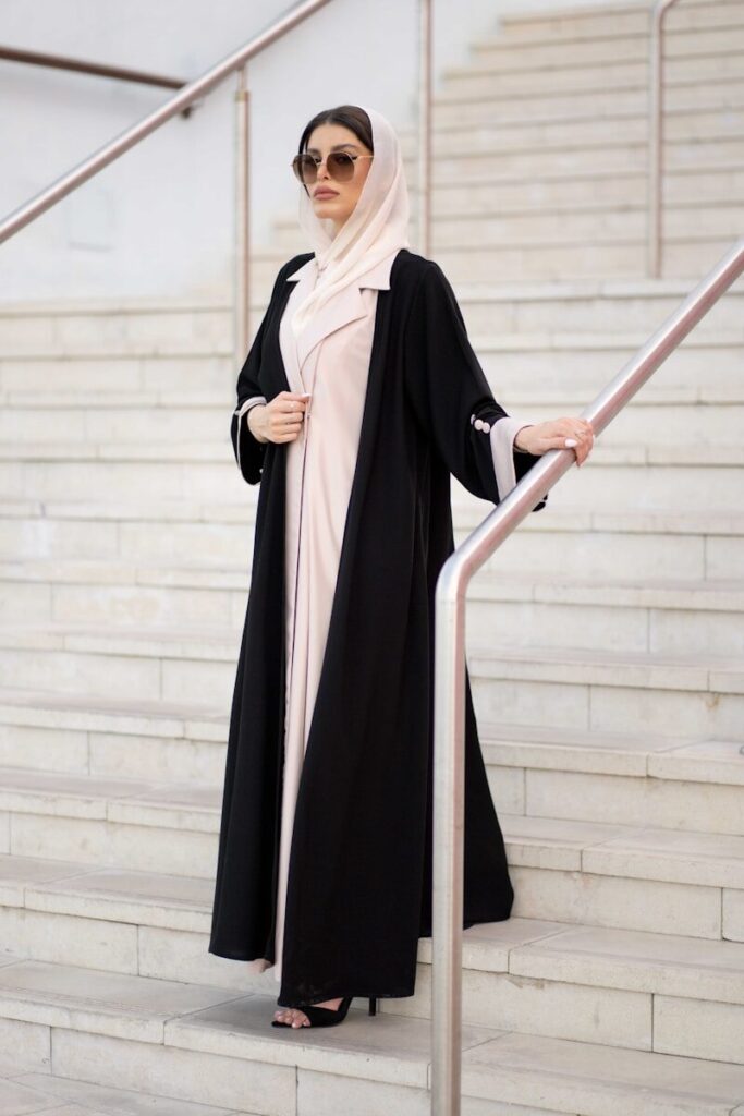 Why High-Quality Linen Is the Perfect Fabric for Summer? A woman in a black and white outfit is standing on a set of stairs